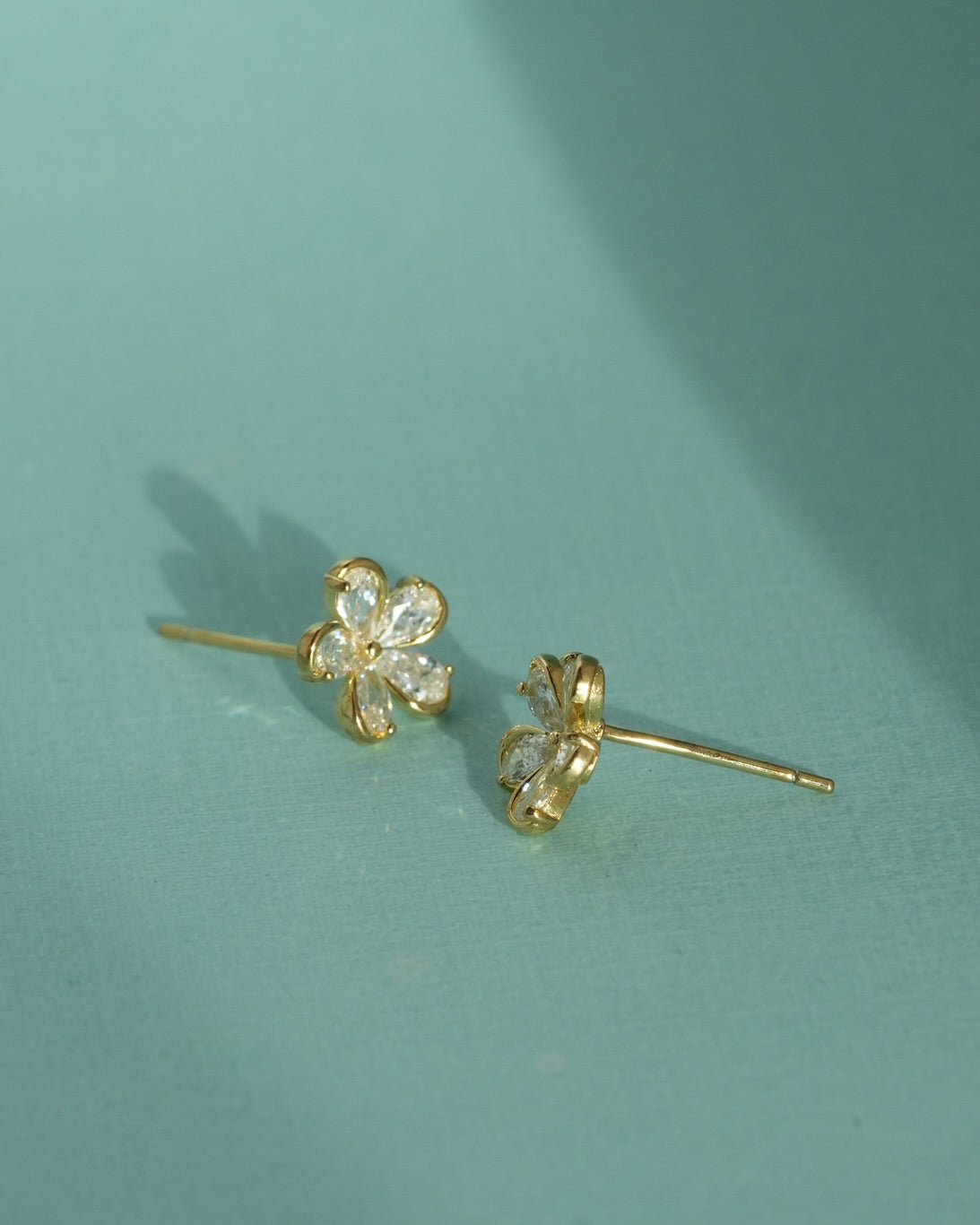 Close of Gold-tone flower-shaped stud earrings with clear stones
