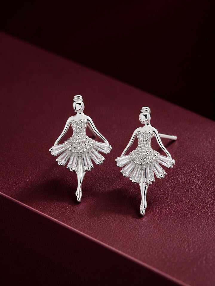 Silver ballerina stud earrings with clear sparkling stones on a burgundy background