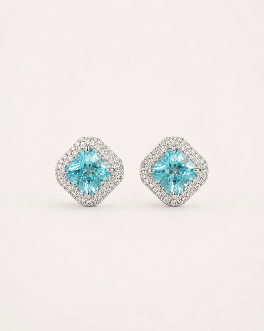 Discover PEHRO’s aquamarine stud earrings in 925 Sterling Silver, featuring a vivid blue aquamarine centre framed by brilliant stones for a refined finish.