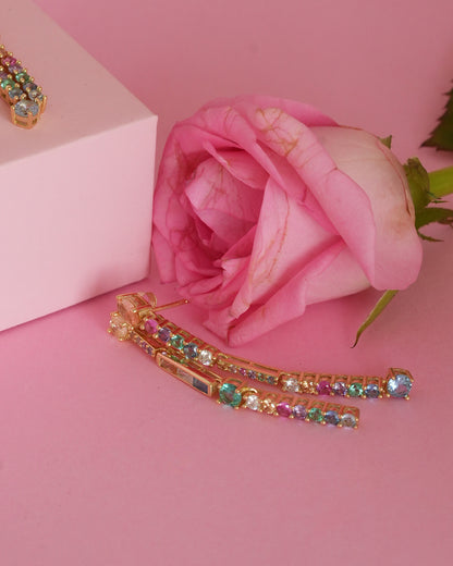 Close up of rainbow earring photographed on pink background 