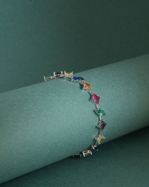 The 925 Sterling Silver Multicolor Station Bracelet draped over a minimal sculptural form, highlighting its lightweight construction and rhodium finish.