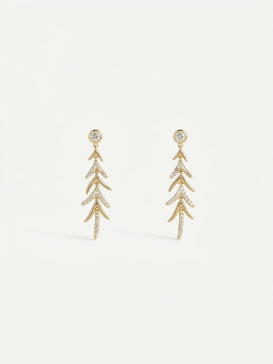 A pair of gold drop earrings with a leaf or branch-like layered design, embellished with small clear stones,