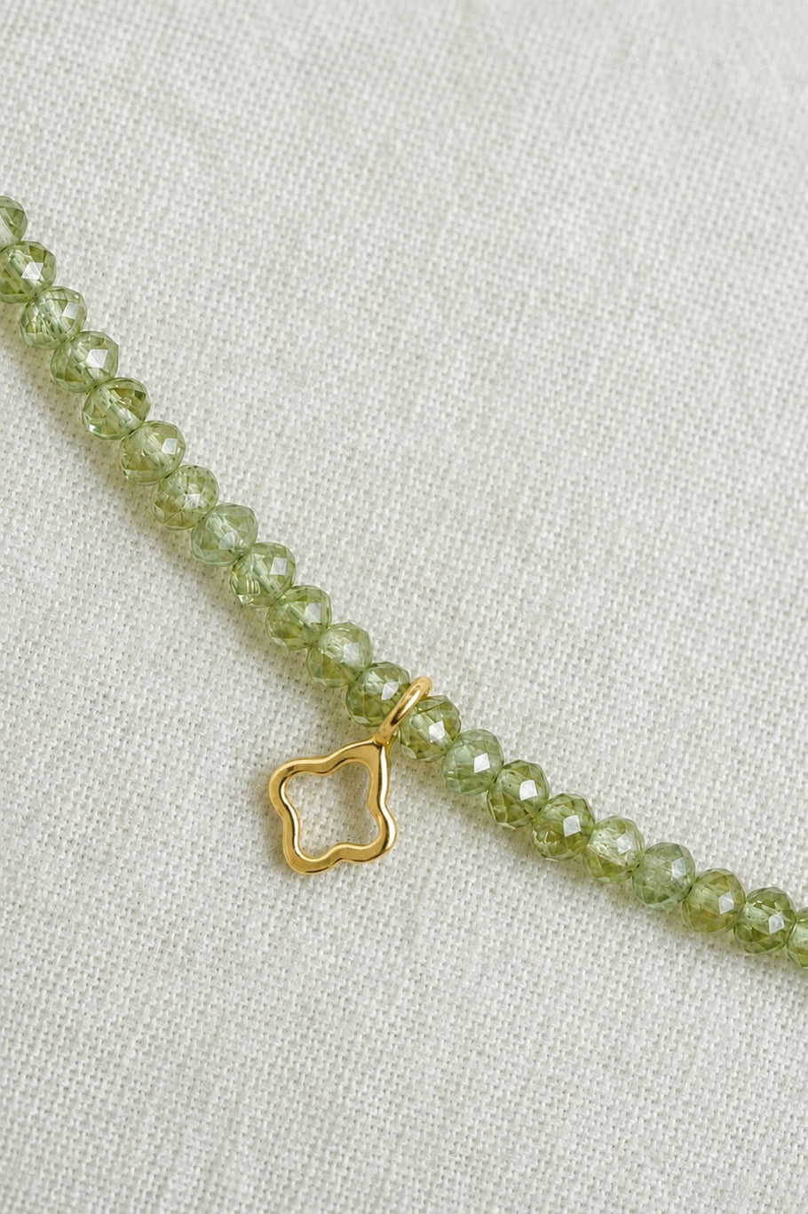 Faceted natural peridot gemstone choker with pale green beads and gold crescent, quatrefoil and heart charms by PEHRO