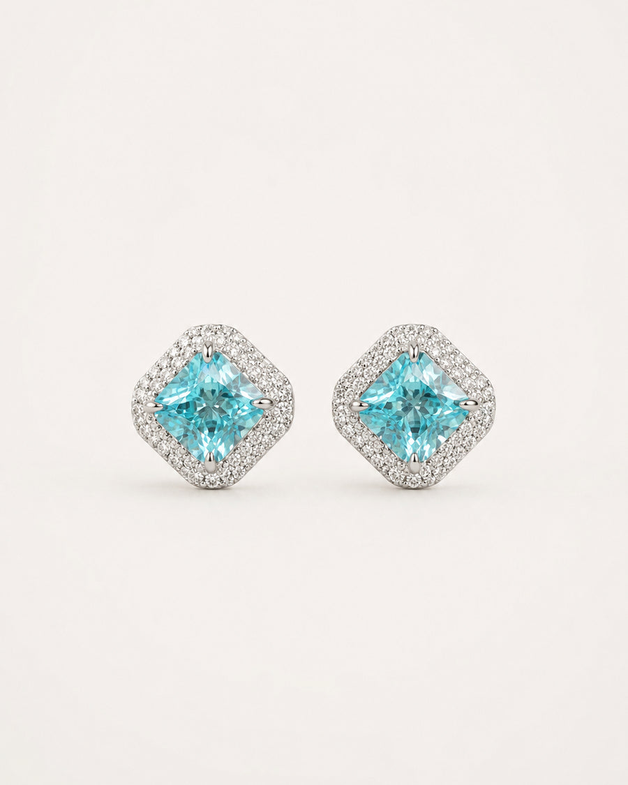 Discover PEHRO’s aquamarine stud earrings in 925 Sterling Silver, featuring a vivid blue aquamarine centre framed by brilliant stones for a refined finish.