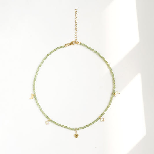 Faceted natural peridot gemstone choker with pale green beads and gold crescent, quatrefoil and heart charms by PEHRO