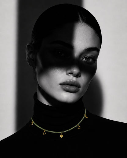 Woman wearing PEHRO Peridot beaded choker necklace with gold-finished charms