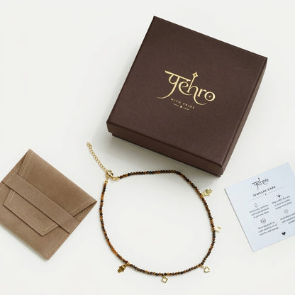 Natural Tiger Eye beaded charm necklace with five 18K gold charms, including hand, flower and heart motifs. Box 