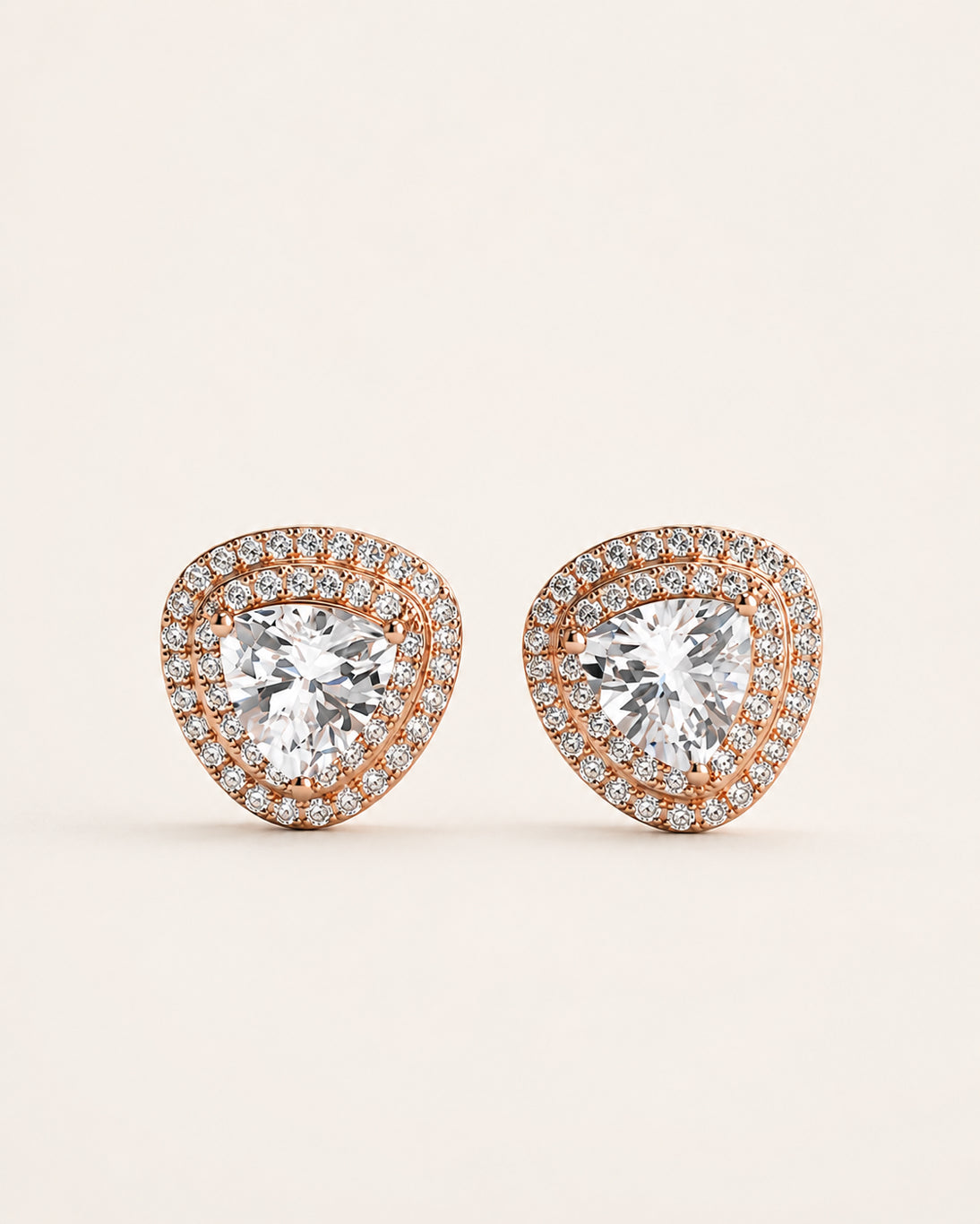 Rose gold-tone 925 sterling silver stud earrings with large pear-shaped brilliant stones and double halo detailing, on a light background.