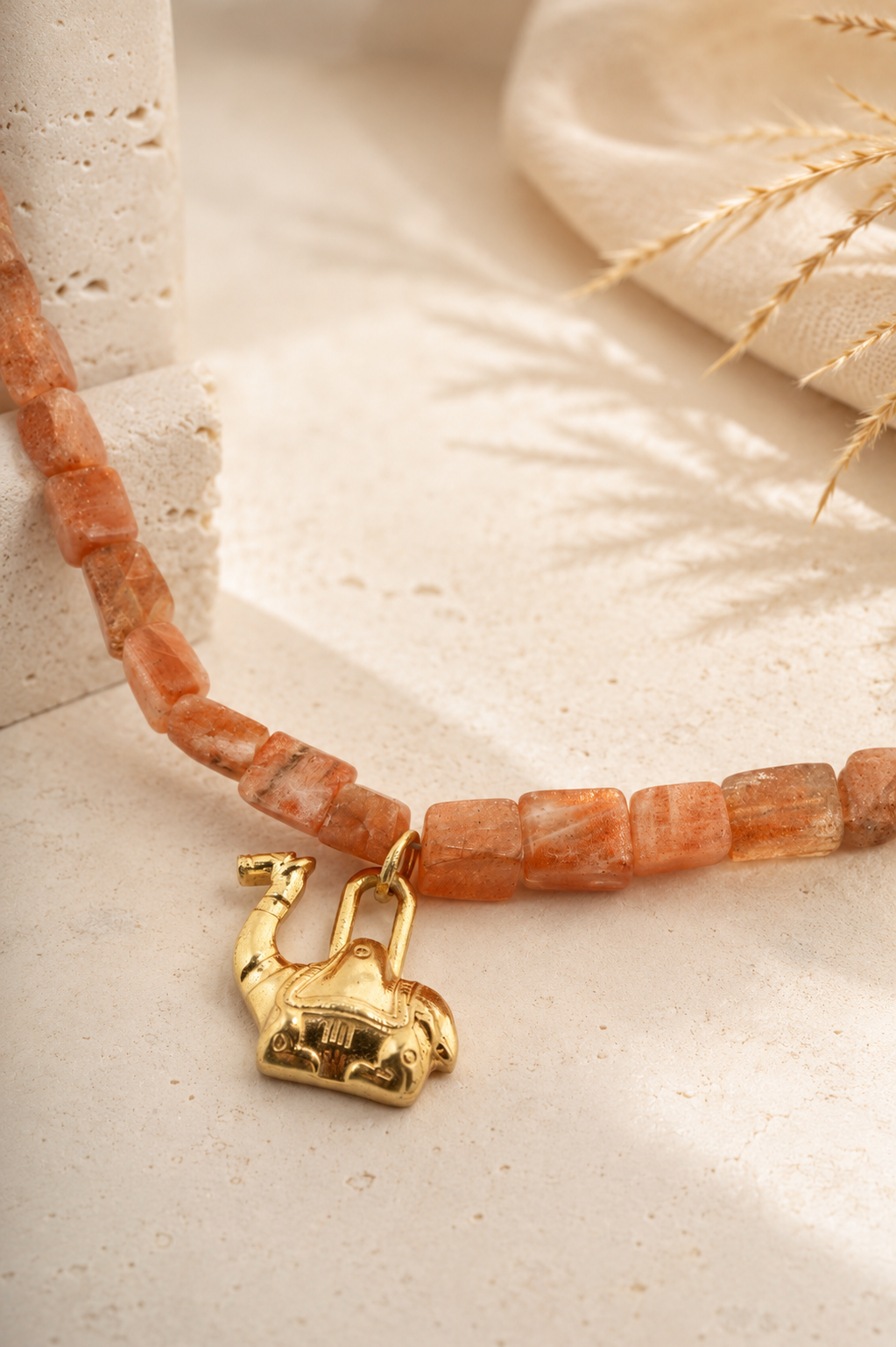 Close-up of the elephant charm and natural sunstone beads on the PEHRO Sunstone Choker